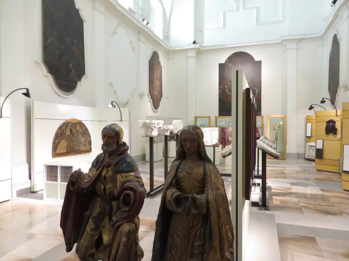 Interior of the Museo Diocesano di Capua in Italy, featuring religious artifacts, sculptures, and sacred art displayed within a historic building, with arched ceilings and soft lighting enhancing the museum's reverent atmosphere.