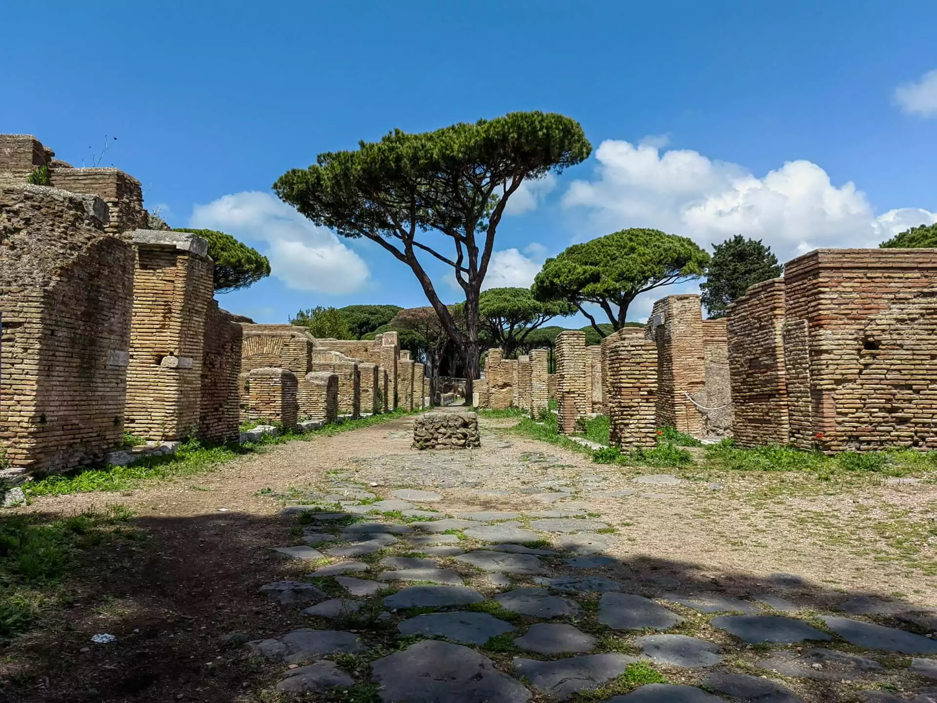 Ancient ruins of Ostia Antica in Italy, featuring crumbling stone buildings, mosaicked floors, and remnants of Roman streets, offering a glimpse into daily life in a once-thriving harbor city of the Roman Empire.