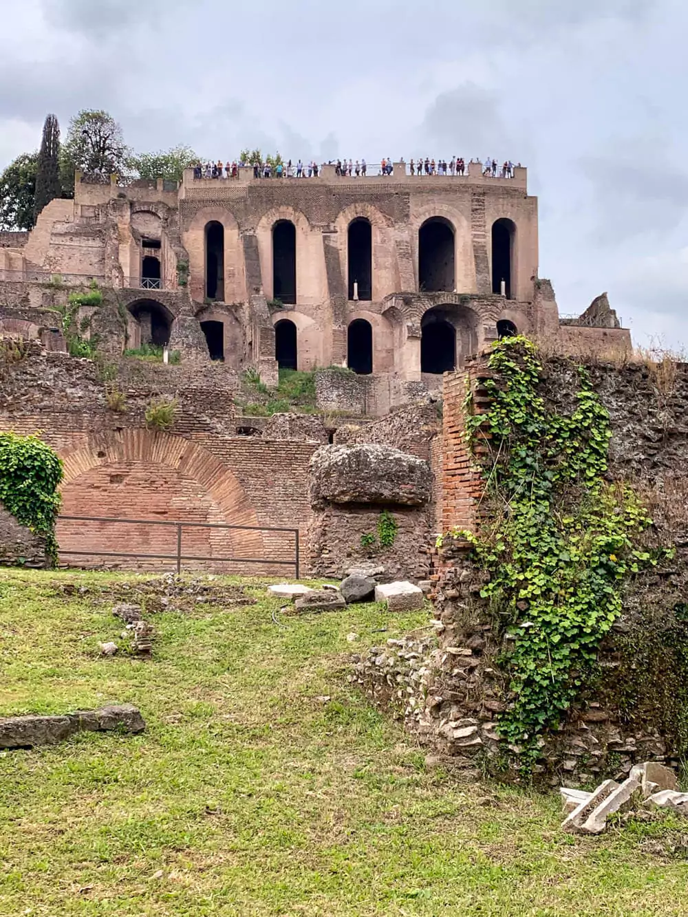Ruins of Domus Tiberiana on Palatine Hill in Rome, Italy, showcasing ancient brick arches, crumbling walls, and remnants of the imperial palace complex overlooking the Roman Forum.