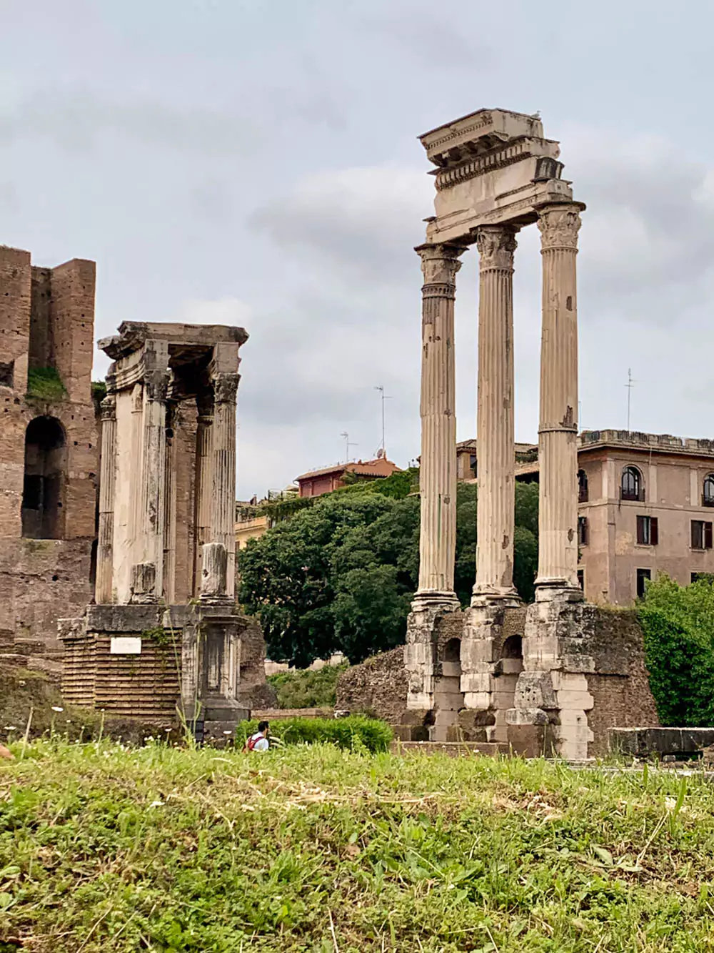 Il Tempio dei Dioscuri, or Temple of Castor and Pollux, in the Roman Forum, featuring three towering Corinthian columns rising from a high podium—the only remains of the ancient temple dedicated to the twin gods of Roman mythology.