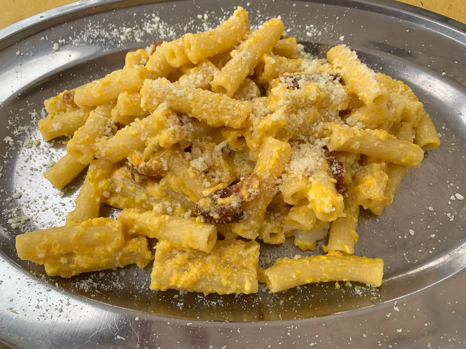 Plate of freshly made cacio e pepe served for lunch in Rome, Italy, featuring perfectly coated pasta with Pecorino Romano and cracked black pepper — a classic Roman dish