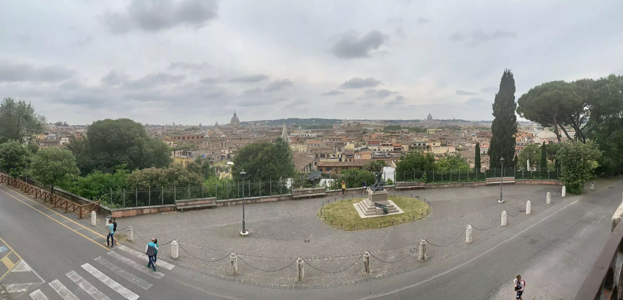 Sweeping view of Rome from the Terrazza Viale del Belvedere, featuring a panoramic skyline dotted with historic domes, rooftops, and monuments under a bright, open sky.