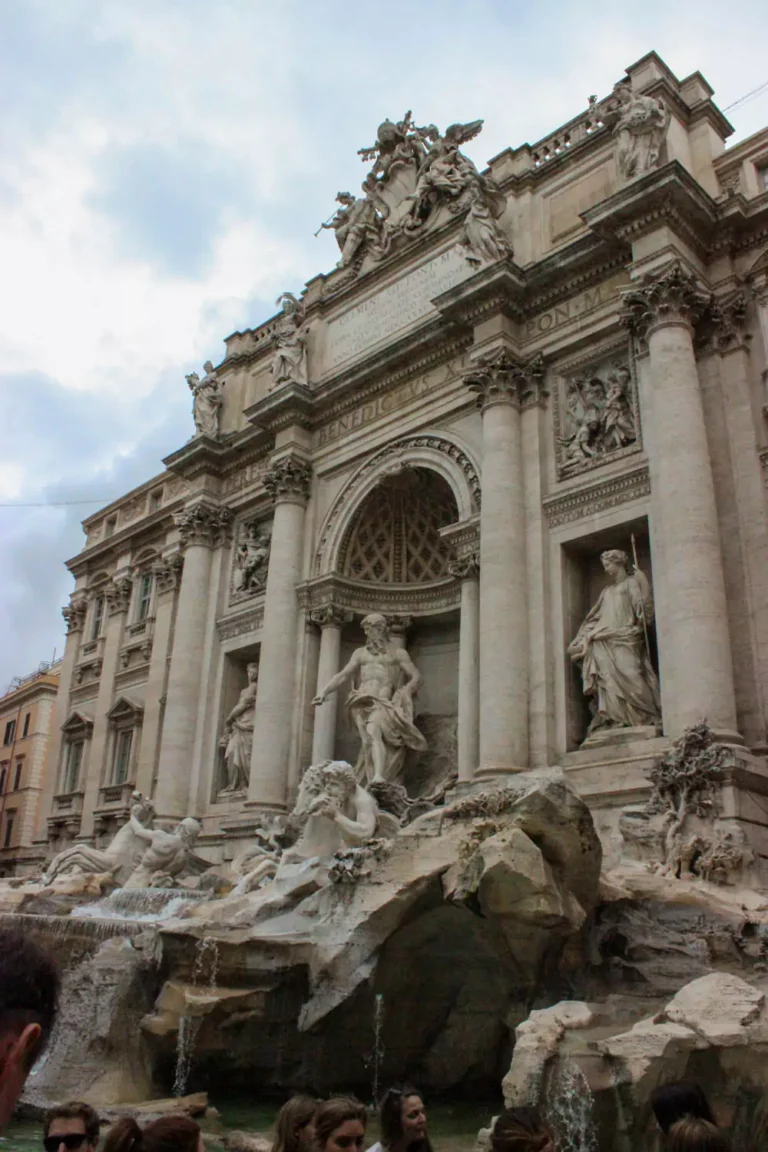 Up-close view of the Trevi Fountain in Rome, Italy, showcasing the dramatic marble sculptures of Oceanus and mythological figures with cascading water flowing into the ornate stone basin.