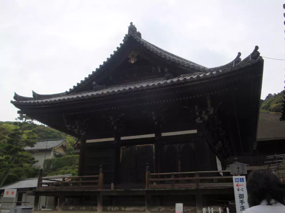 Kiyomizu-dera Temple in Kyoto, Japan, perched on a hillside with its famous wooden stage extending over a lush valley. The historic temple offers sweeping views, traditional pagoda-style architecture, and vibrant seasonal foliage.