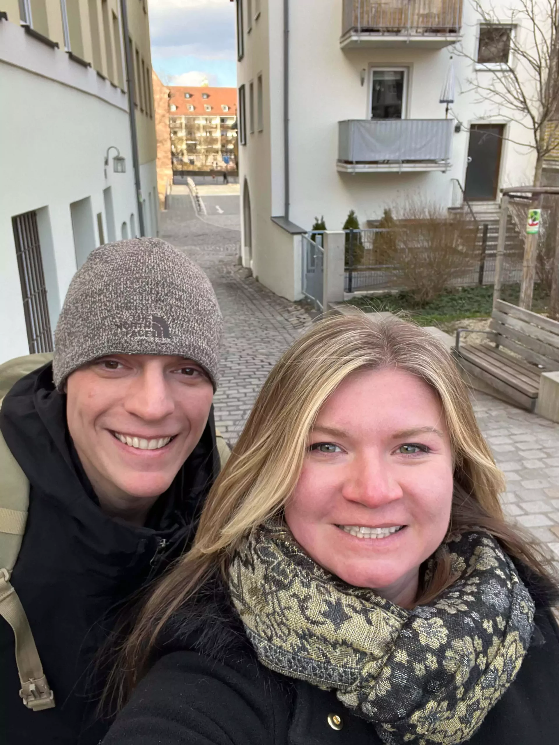 Katie and Zack take a cheerful selfie while walking through Nuremberg’s old town in Germany. Behind them, cobblestone streets and historic buildings set the scene with classic European charm.