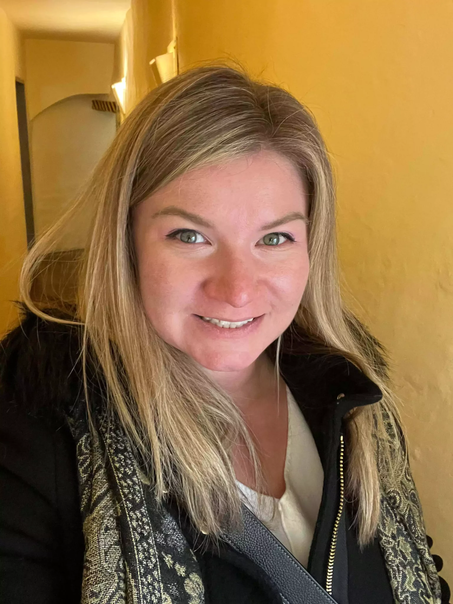 Katie takes a selfie inside Mozart’s Birthplace in Salzburg, Austria, surrounded by bright yellow walls and historic displays. Her smile captures the excitement of exploring the famous composer’s home.