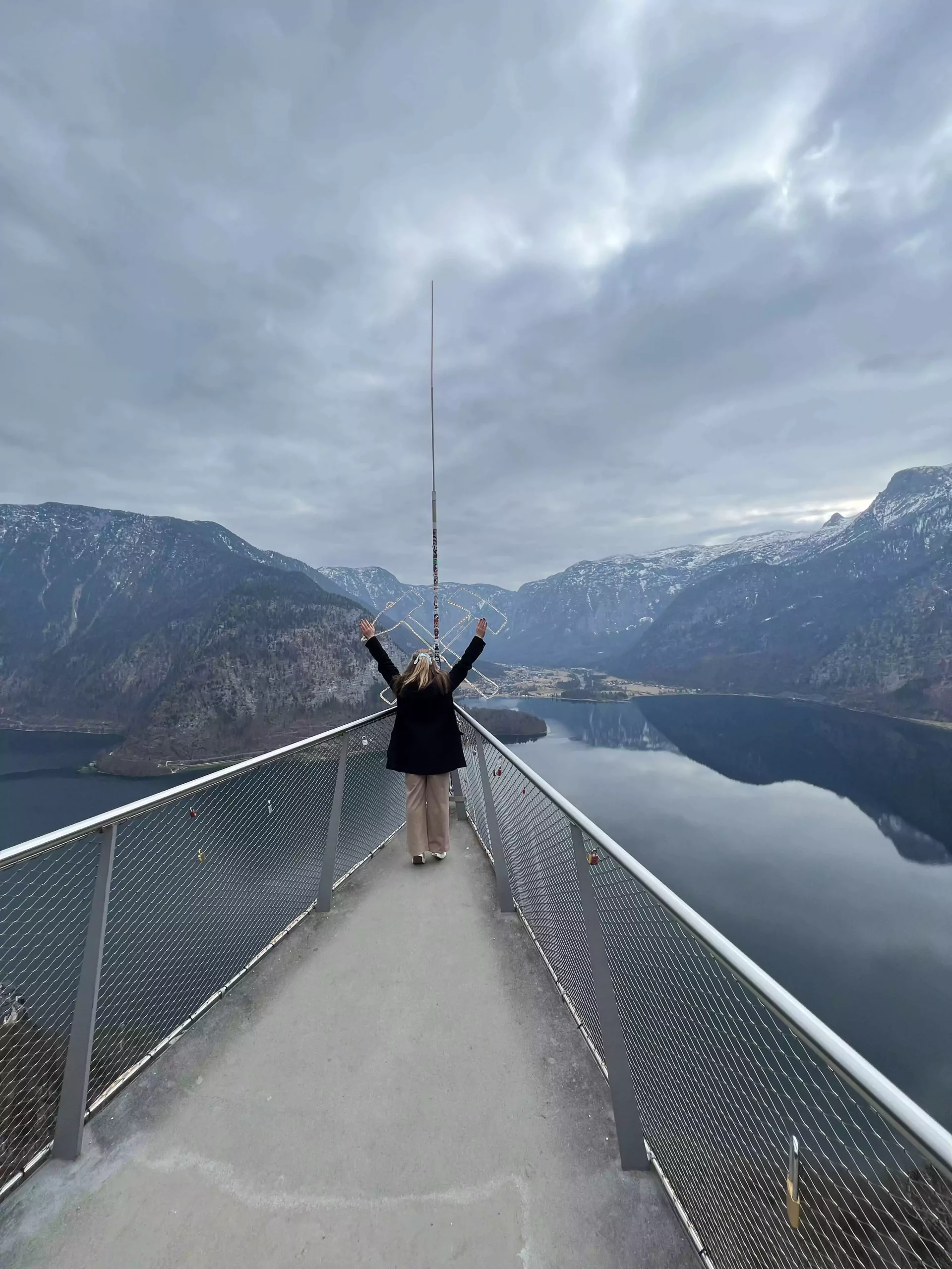 Katie stands at the top of the Hallstatt Skywalk Welterbeblick, overlooking the breathtaking alpine village and lake far below. The sweeping panoramic view behind her captures the stunning beauty of Austria’s UNESCO World Heritage site.