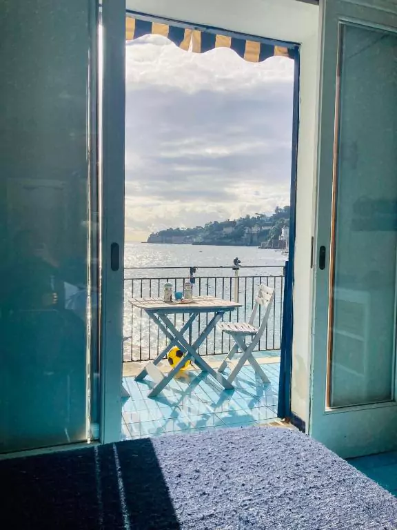 La Perla di Posillipo in Naples, Italy, offering a stunning seaside view from a private terrace, with elegant seating and panoramic vistas of the Gulf of Naples