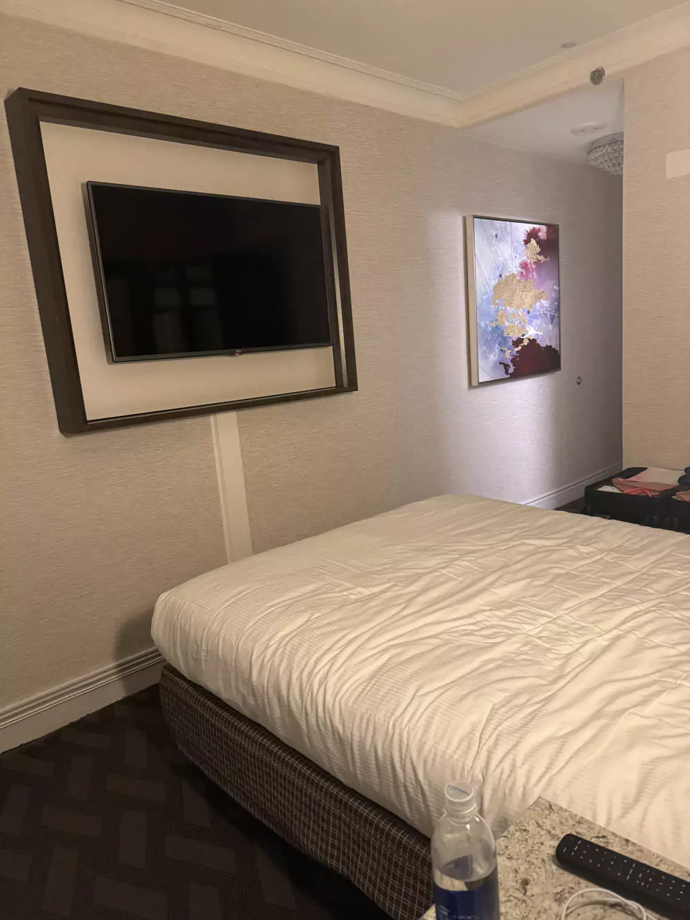 Flat-screen TV mounted on the wall in a guest room at Hilton Boston Park Plaza, positioned facing the bed in a stylish, neutral-toned space.