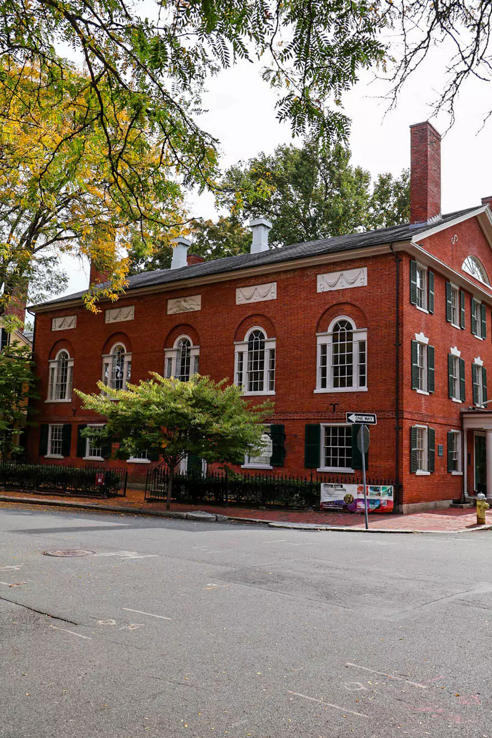 Exterior of Hamilton Hall in Salem, Massachusetts, featuring red brick walls, tall arched windows, and classic white columns. The historic Federal-style building stands as an elegant venue in the heart of the city.