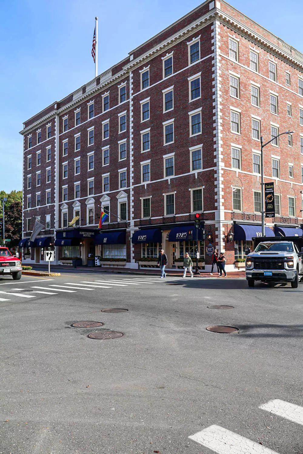 Exterior of the Hawthorne Hotel in Salem, Massachusetts, featuring a classic brick facade with white-trimmed windows and green awnings. This historic hotel exudes timeless elegance and is a popular destination for visitors to the famously spooky town.