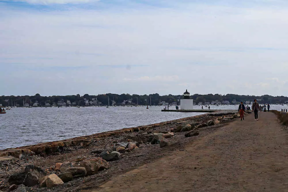 Lighthouse in Salem, Massachusetts, standing at the edge of the harbor with a white tower and black lantern top. Surrounded by rocky shoreline and gentle waves, it adds coastal charm to the historic maritime town.