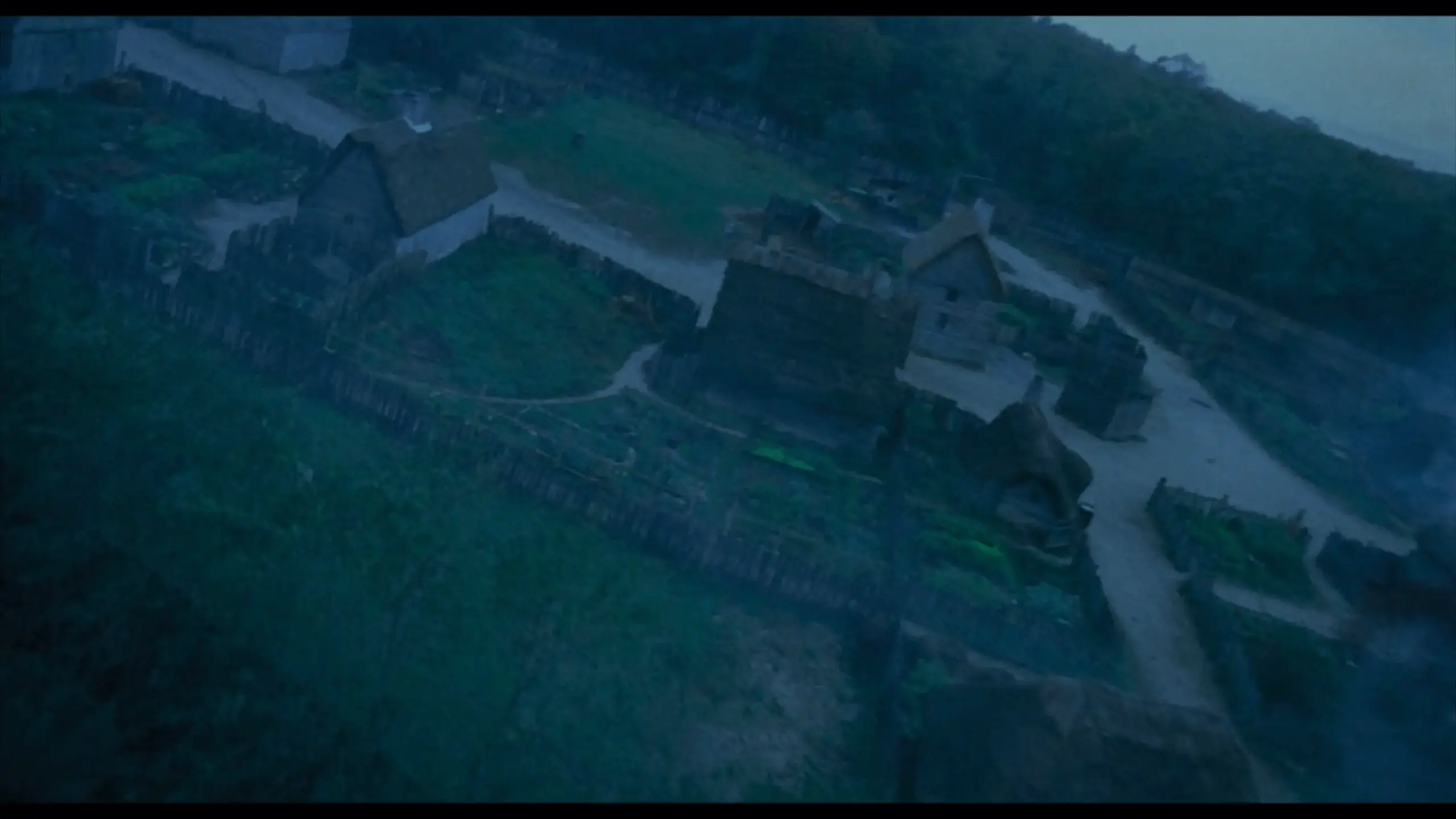 Bird’s-eye view of Pioneer Village in Salem from the opening scene of Hocus Pocus, showing colonial-style buildings with pitched roofs and surrounding trees. The historic village layout is visible, setting the tone for the film’s 17th-century setting.