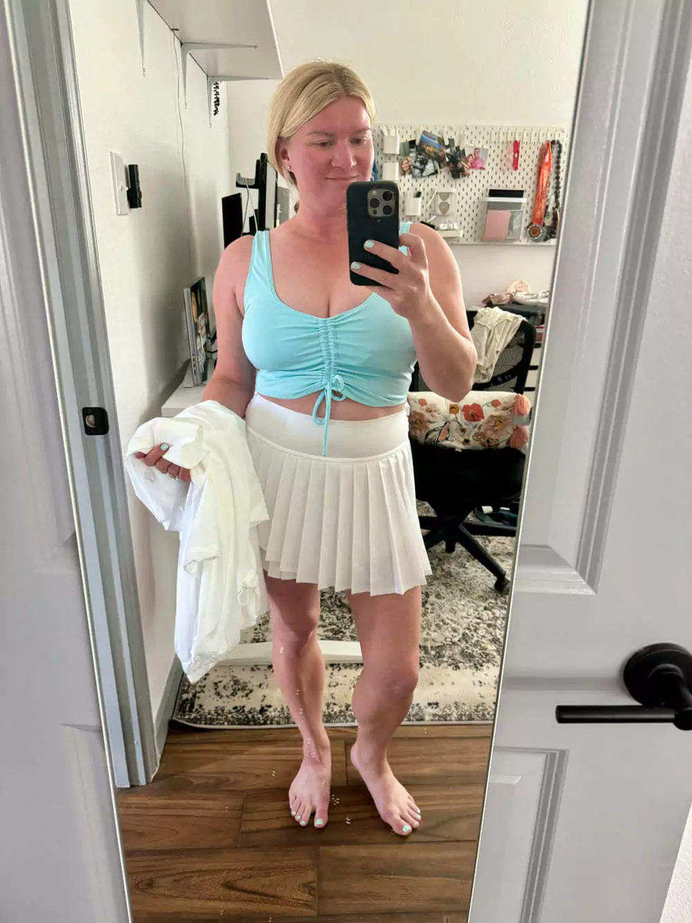 Activewear outfit with a drawstring top, white skort, and zip jacket.