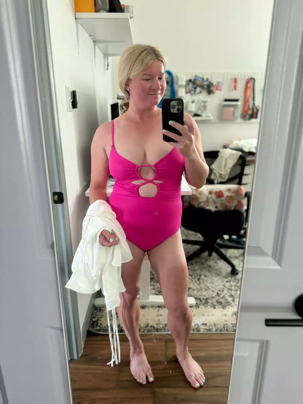 Hot pink one-piece swimsuit paired with a button-up cover-up.