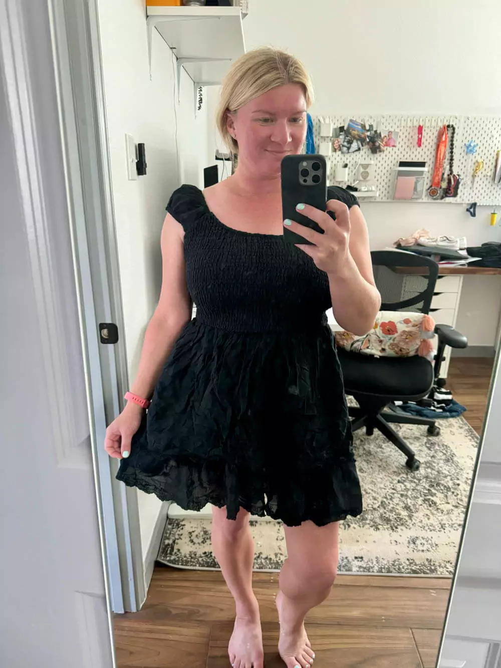Black smocked puff sleeve ruffle mini dress with earrings.