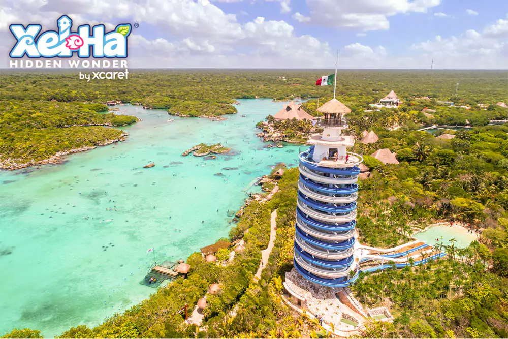 Aerial view of Xel-Há, showcasing its stunning turquoise lagoons, winding rivers, and lush jungle landscape along the Riviera Maya coast. The natural aquatic park’s vibrant water and greenery create a breathtaking tropical scene from above.