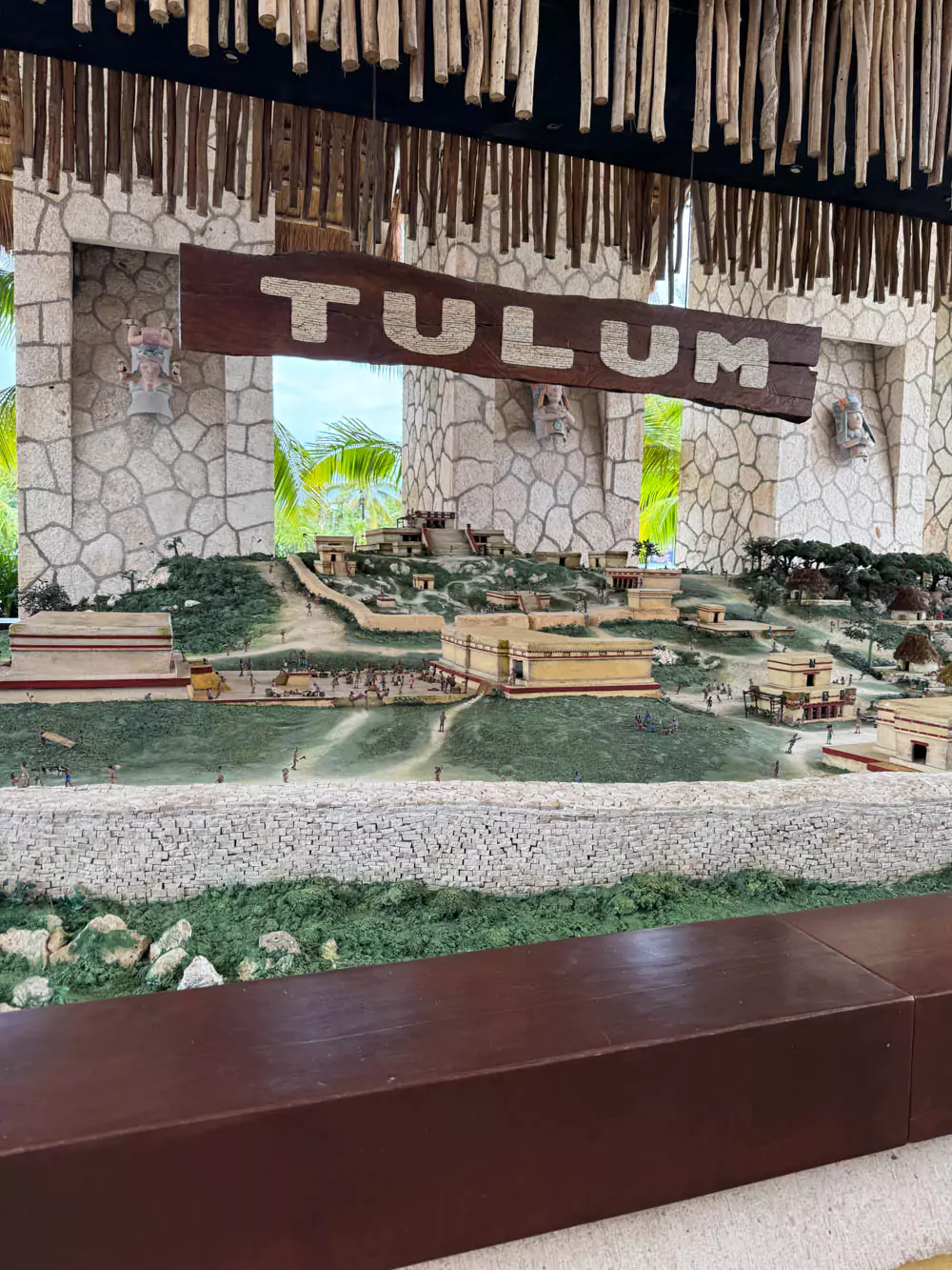 Entrance area of Xel-Há featuring a mini model of Tulum’s ancient ruins, complete with small stone structures and palm trees. The display offers a cultural preview of the region’s rich history as visitors begin their adventure in the natural park.