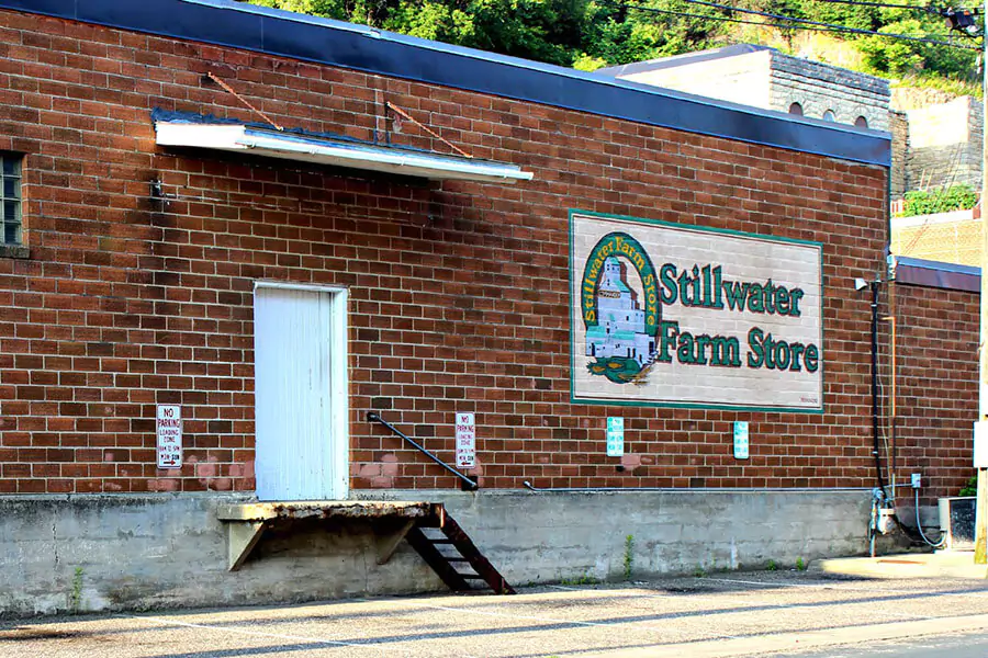 Rustic farm store in Stillwater, Minnesota, with a weathered wooden exterior, barn-style doors, and vintage signage.