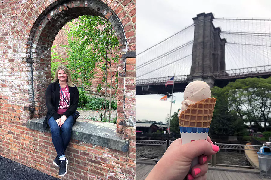 Katie enjoying an ice cream cone in Brooklyn, New York, with a playful smile as she stands near the waterfront. The city skyline and bridge peek through in the background, adding a sweet touch to a sunny day in the borough.
