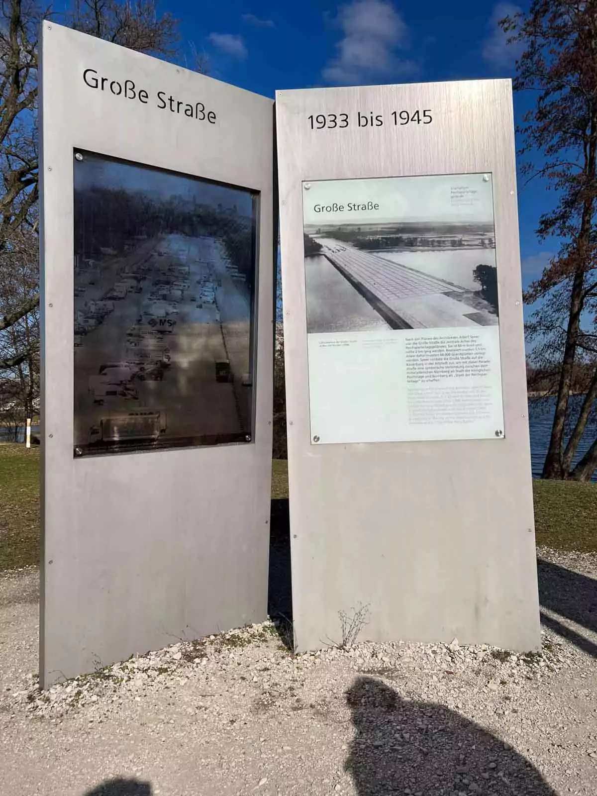 Information sign for the Great Road (Große Straße) at the former Nazi rally grounds in Nuremberg, Germany, providing historical context and images about the wide, granite-paved parade route aligned with the Zeppelin Field.