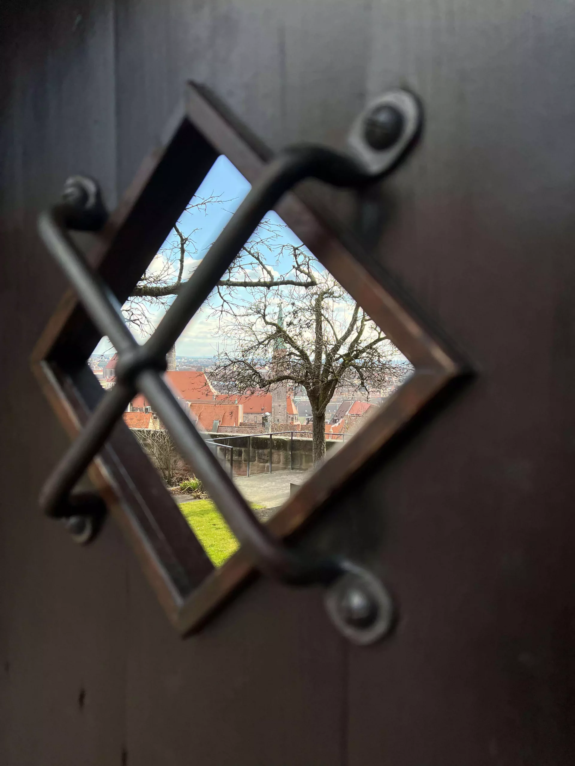 A window on a door looking out to the Nuremberg's Castle Gardens