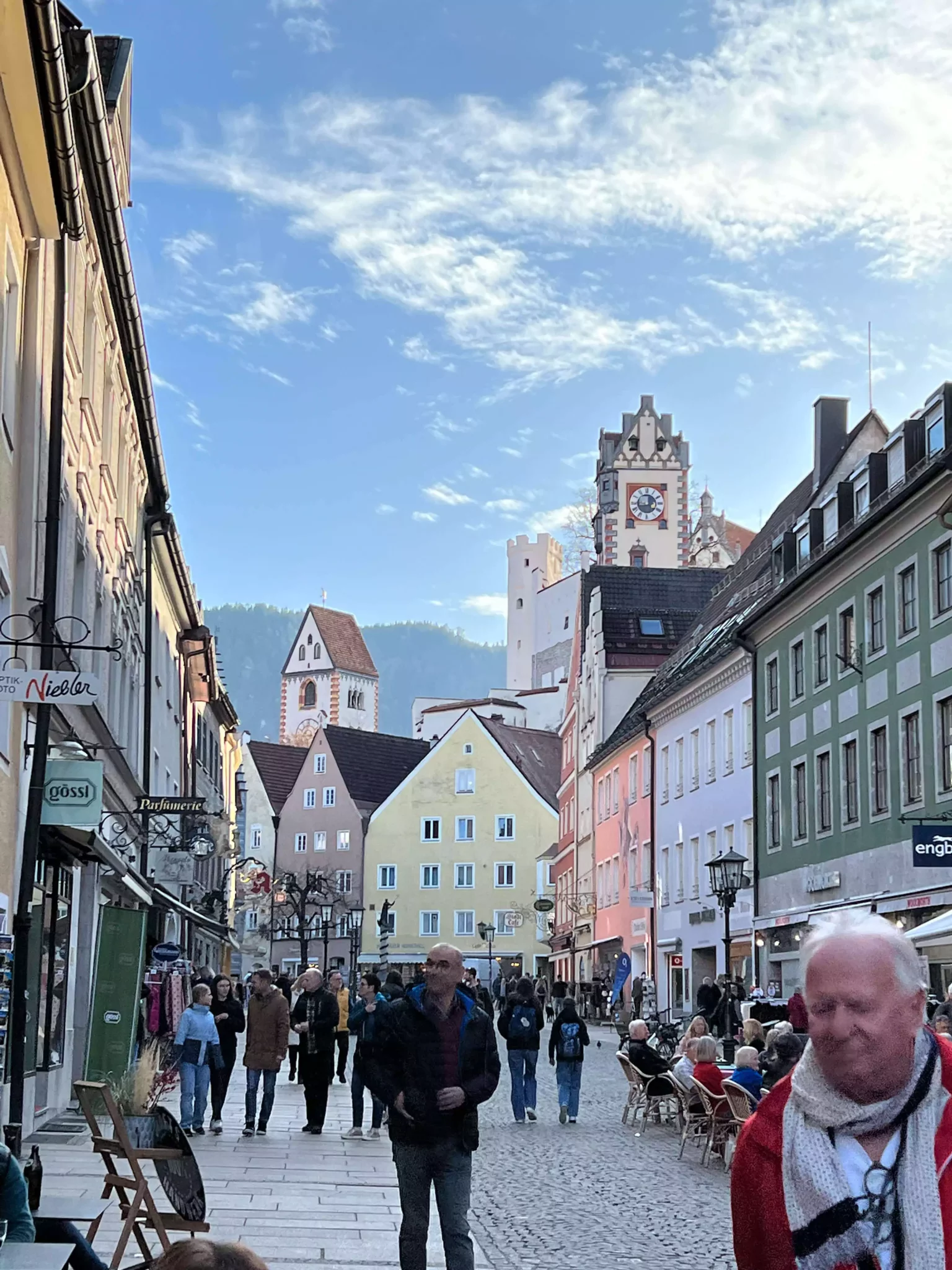 Row of colorful historic buildings in Füssen, Germany, with pastel facades, painted details, and alpine-style architecture lining a charming cobblestone street.