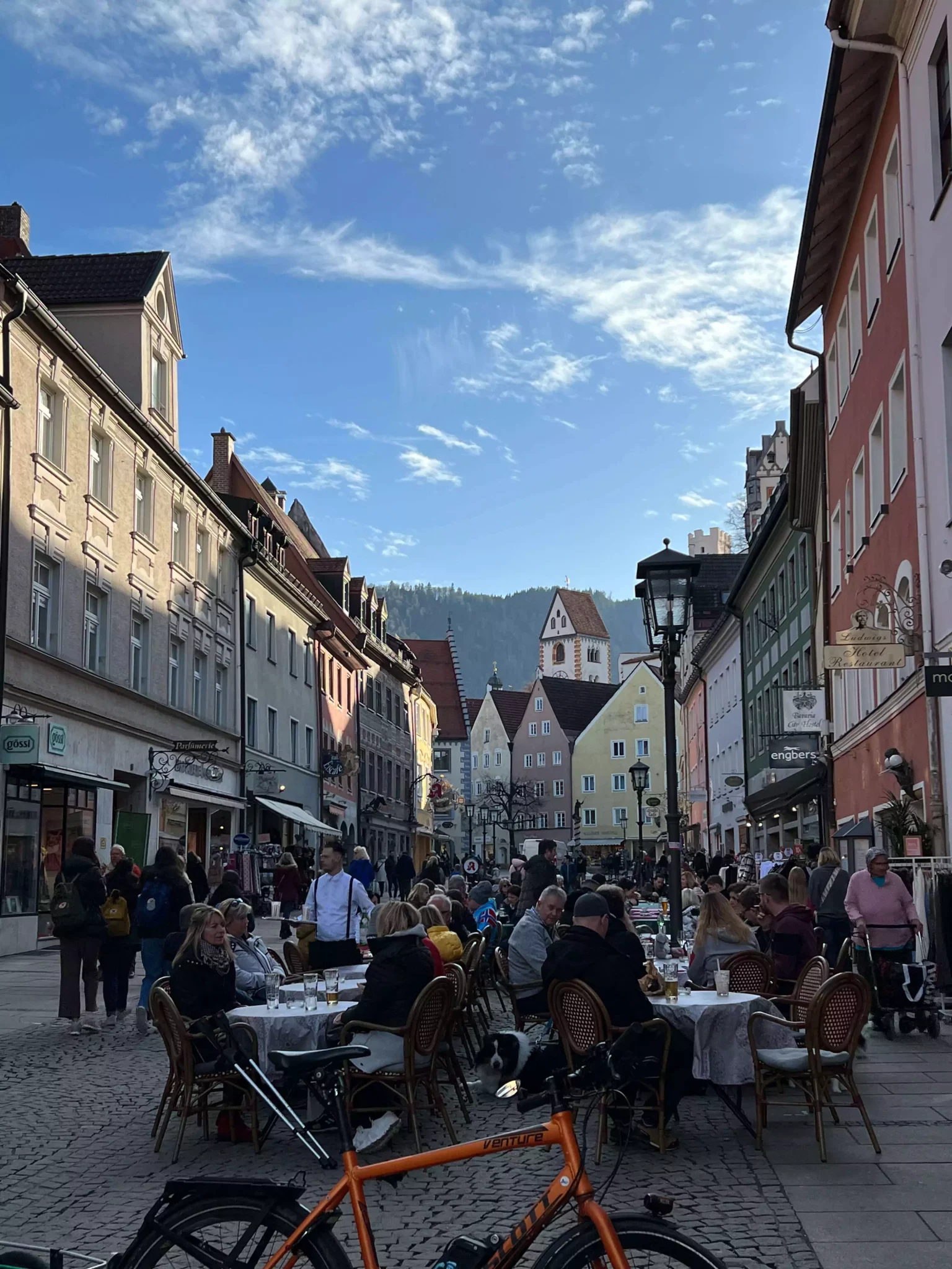 Row of colorful historic buildings in Füssen, Germany, with pastel facades, painted details, and alpine-style architecture lining a charming cobblestone street.