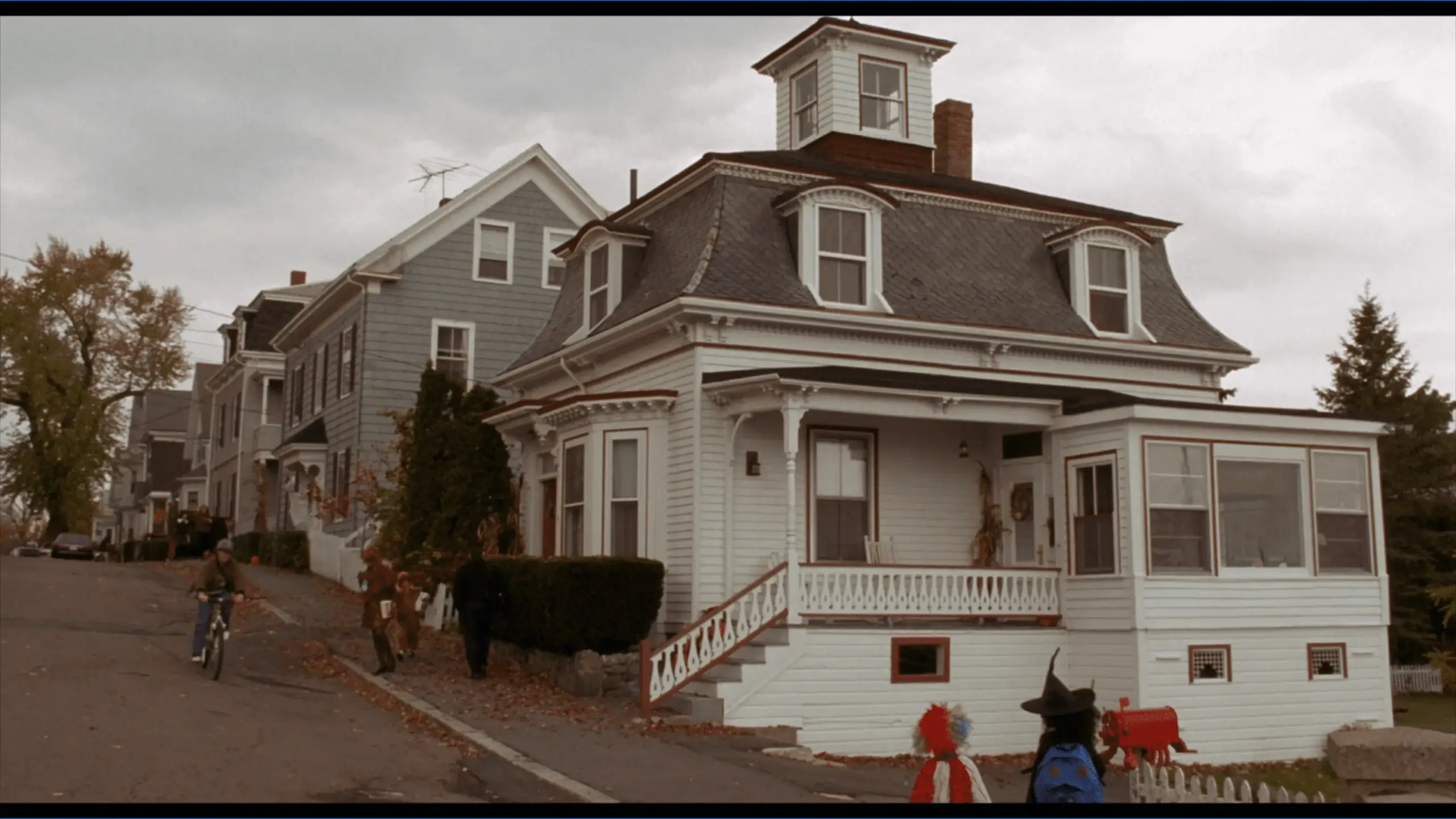A charming colonial-style house at 4 Ocean Avenue in Salem, known as Max and Dani’s home in Hocus Pocus. The white facade with black shutters and a neatly kept yard reflects a cozy suburban setting featured in the film.