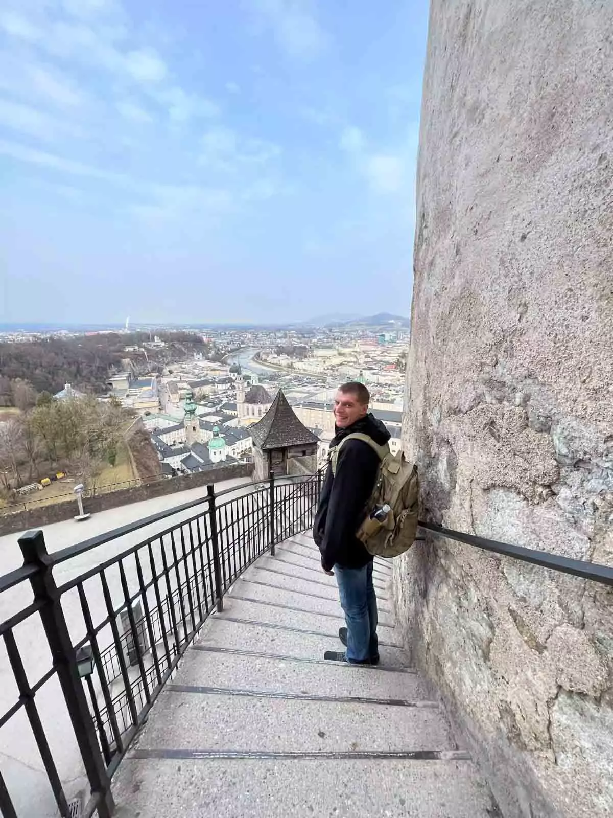 Zack standing on the stone stairs at Fortress Hohensalzburg in Salzburg, Austria, surrounded by historic walls and medieval architecture with panoramic views nearby.