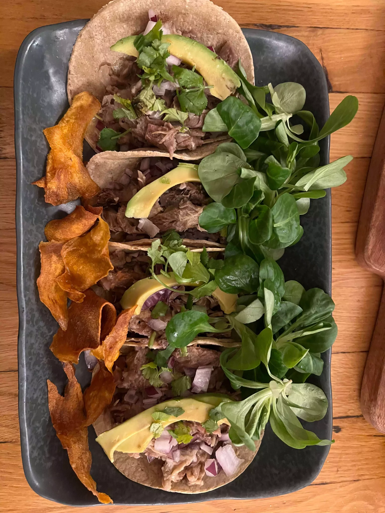 A trio of beef tacos from Die Cabreras in Salzburg, Austria, filled with juicy, spiced beef and garnished with fresh cilantro and diced onions. The vibrant toppings and soft corn tortillas offer an authentic, mouthwatering Mexican flavor experience.