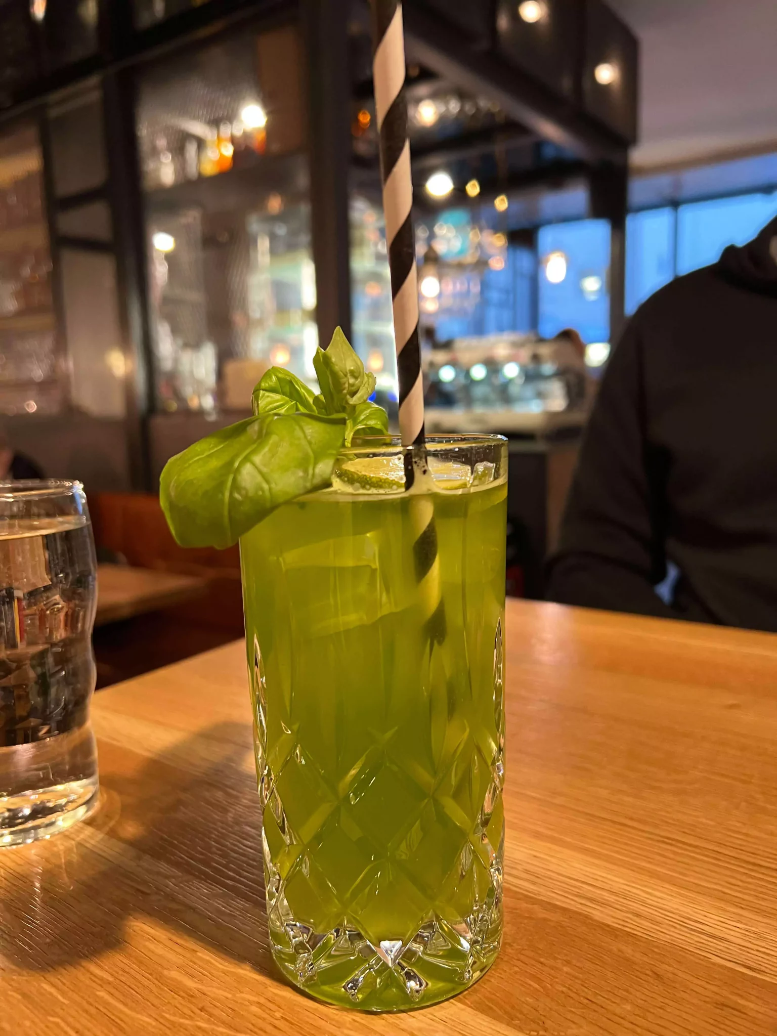 Fresh green mojito served at Ludwig restaurant in Salzburg, Austria, garnished with mint leaves and lime slices, in a tall glass with crushed ice—perfectly paired with a gourmet burger dinner.