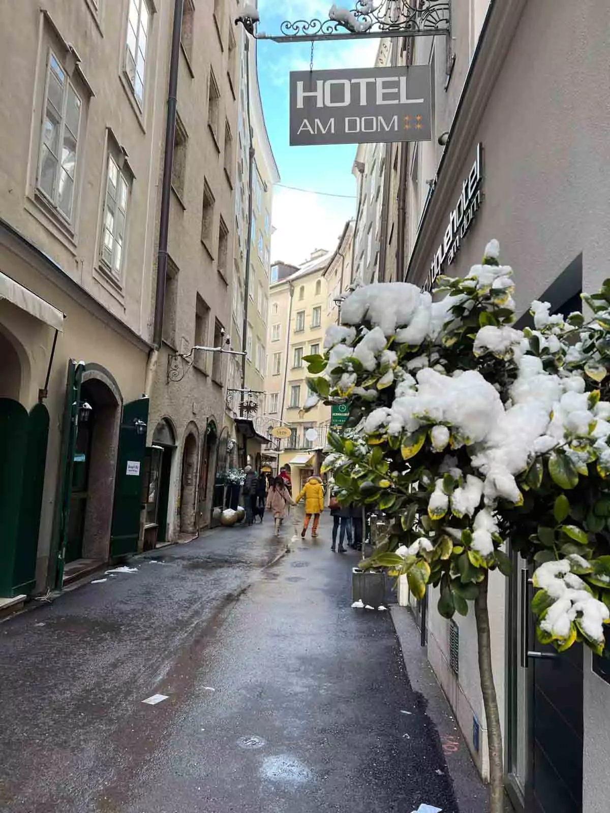 Charming narrow alley in Salzburg’s Old Town, Austria, with historic stone walls and a hanging “Hotel Am Dom” sign, capturing the cozy, old-world atmosphere of the city’s pedestrian lanes.