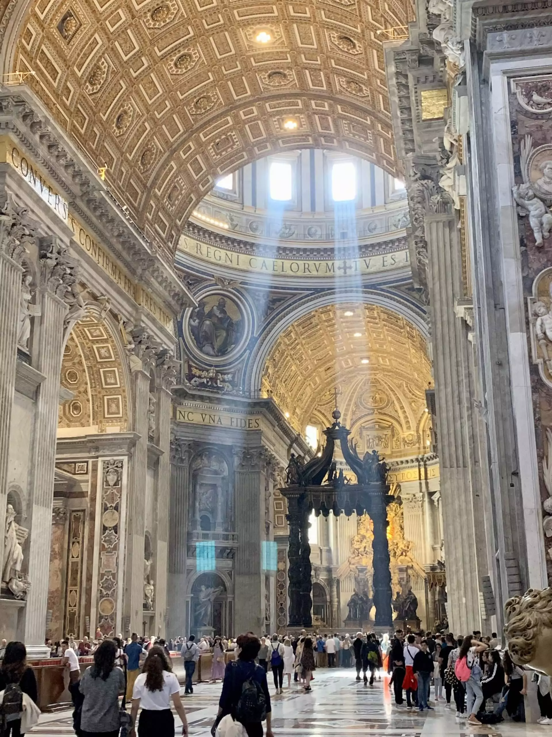 Interior of St. Peter’s Basilica in Vatican City, showcasing soaring marble columns, intricate gold detailing, and the magnificent dome towering above the ornate altar.