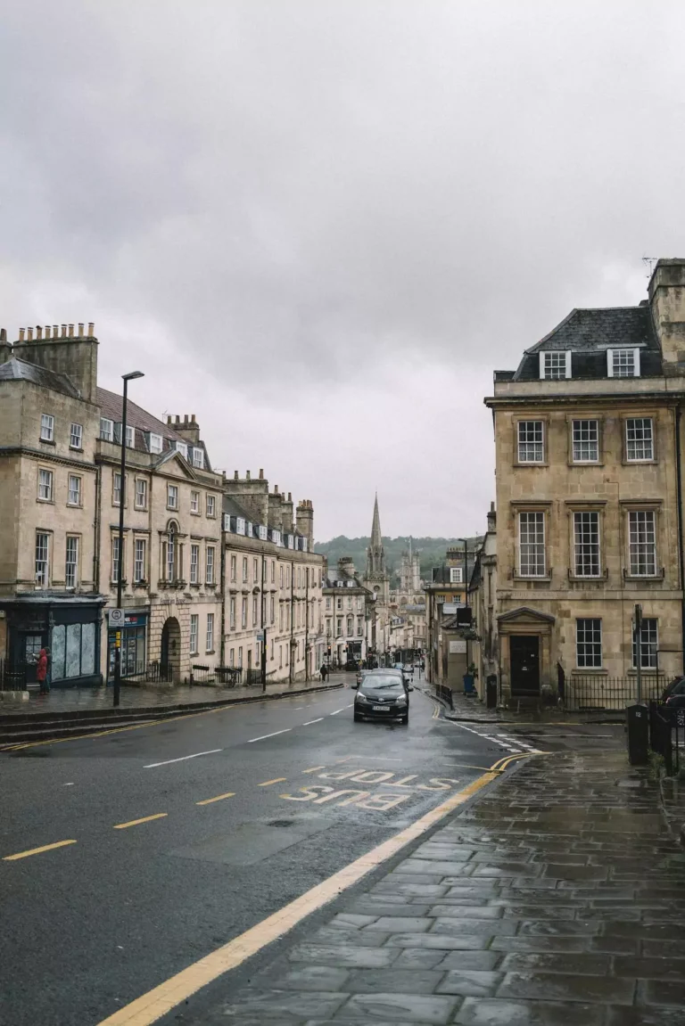 Empty street in Bath, United Kingdom, lined with Georgian limestone buildings and classic black lamp posts, capturing the city’s historic charm in soft natural light.