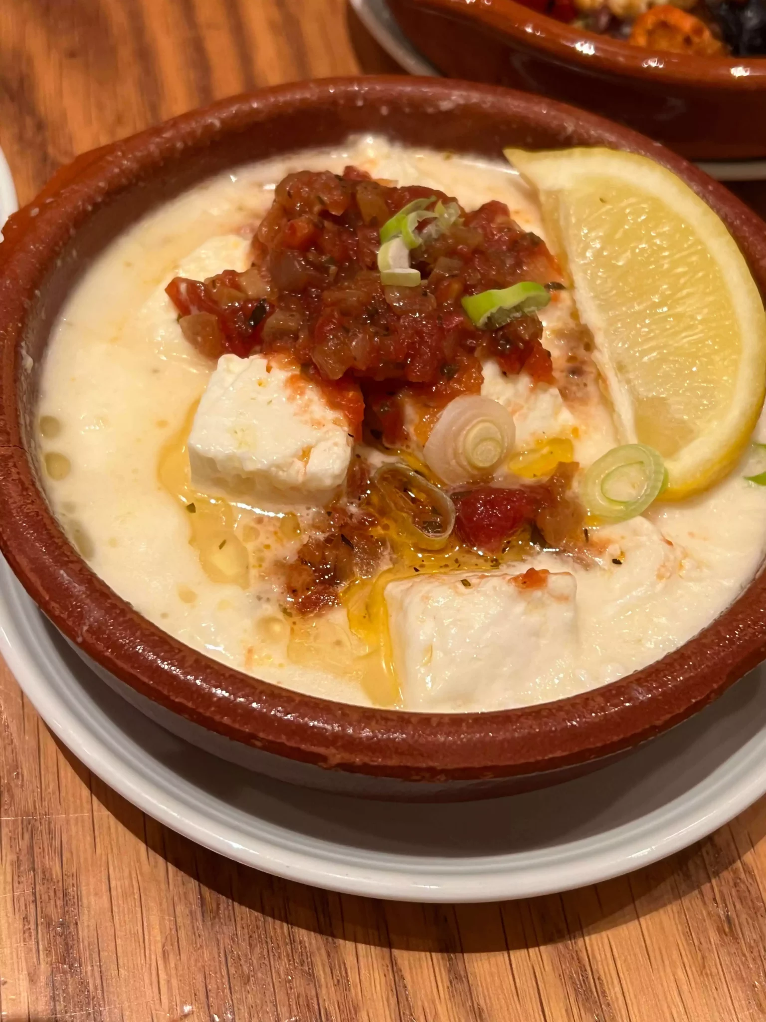 Warm Feta Cheese in Olive Oil with Tomatoes and Onions, with a Bread Basket