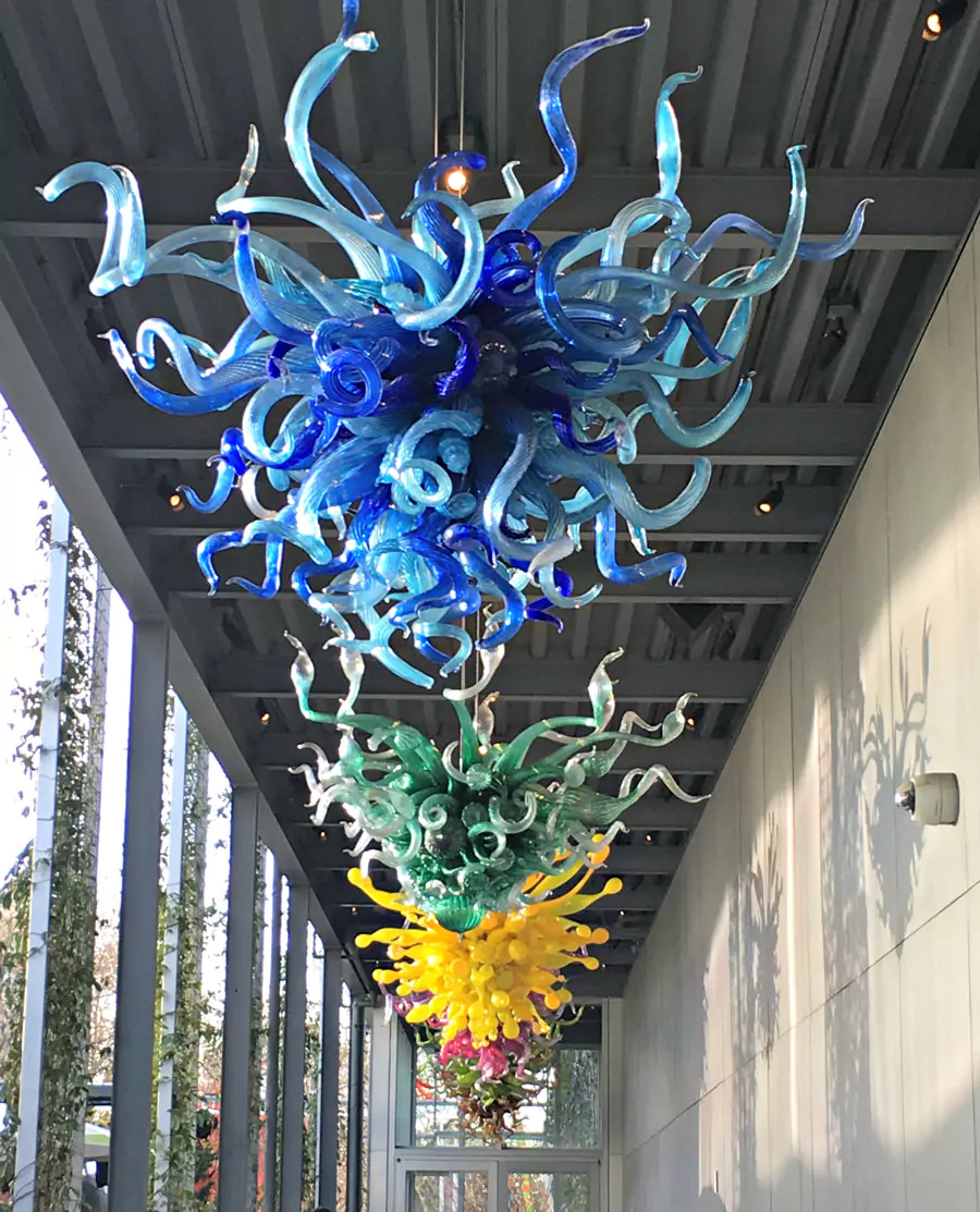 Chihuly Garden and Glass Museum in Seattle, Washington, featuring a striking glasshouse structure surrounded by vibrant outdoor glass sculptures. The museum showcases Dale Chihuly’s colorful, larger-than-life artwork against the backdrop of the Space Needle.
