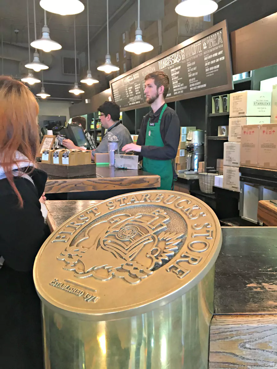 the first Starbucks store at Pike Place Market in Seattle, featuring the original brown logo and vintage storefront signage.