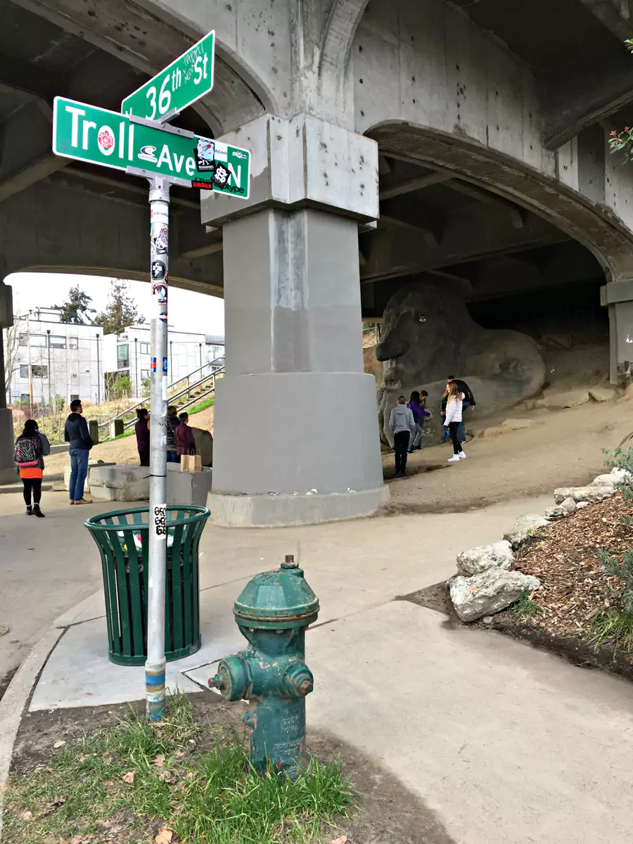 The Fremont Troll statue in Seattle, a large concrete sculpture under a bridge clutching a real Volkswagen Beetle. Its whimsical and slightly eerie design makes it a beloved public art landmark in the city’s quirky Fremont neighborhood.