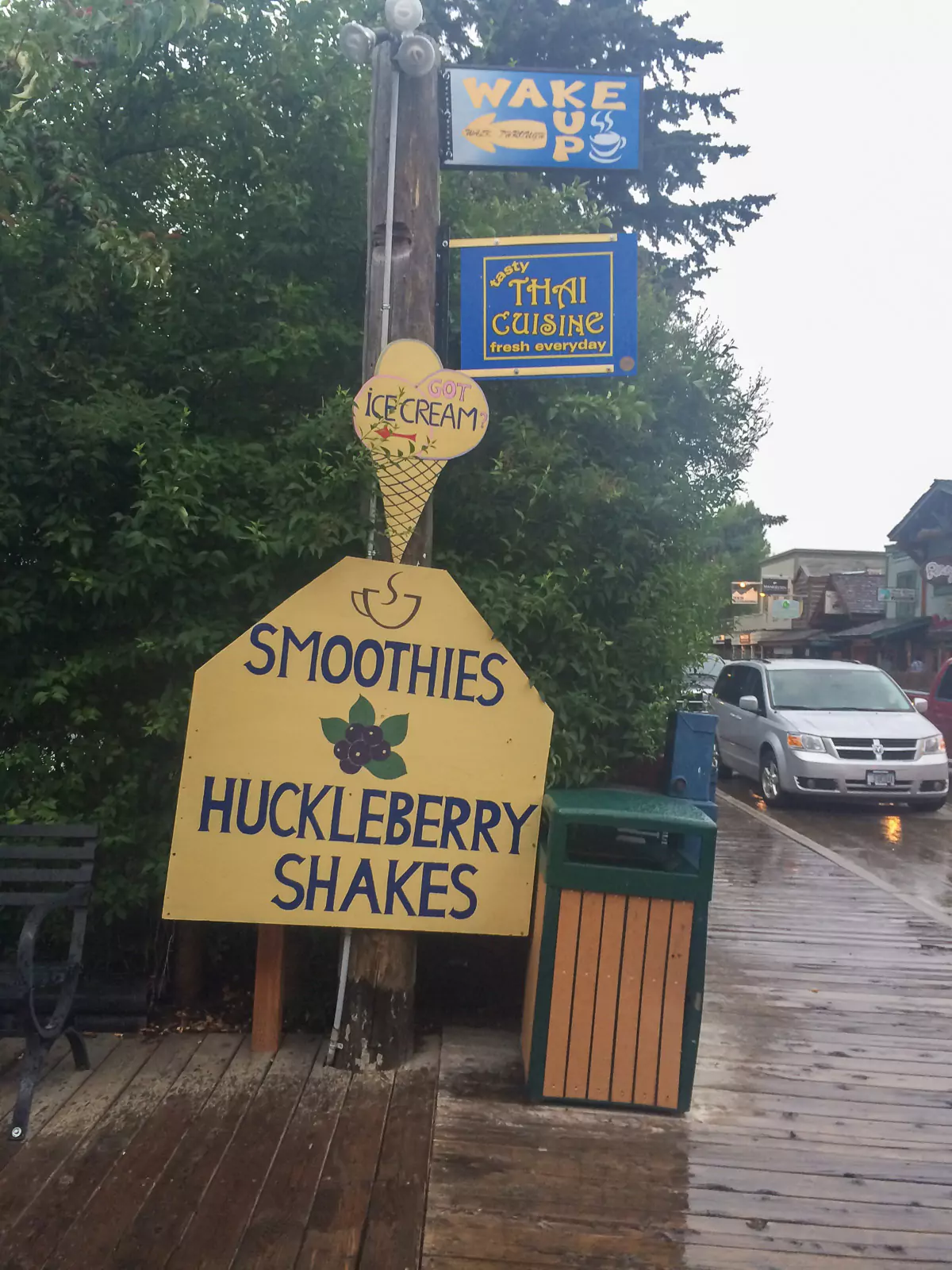 A colorful sign advertising Huckleberry Shakes in Jackson Hole, Wyoming, featuring bright lettering and playful design. The sign invites visitors to enjoy a local sweet treat popular in the area.